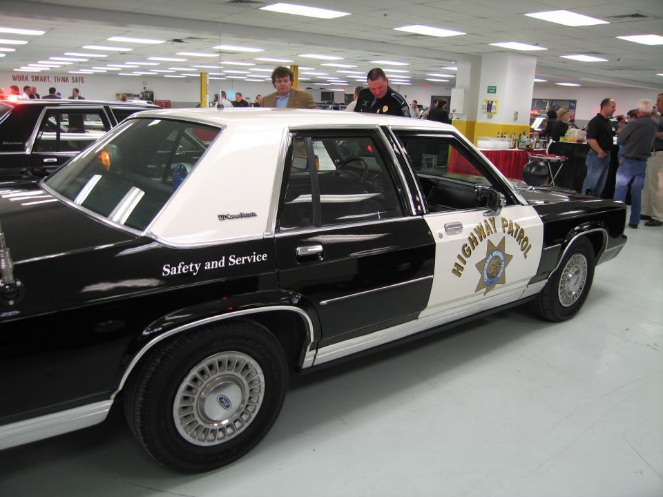 Black-and-white CHP Highway Patrol Ford sedan, side view, indoors