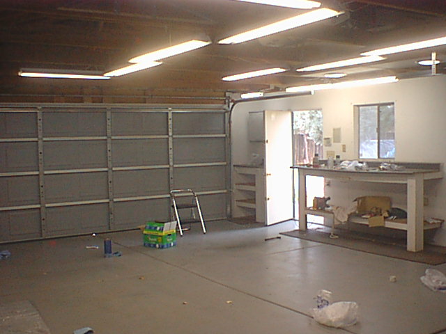 Garage interior with sectional door, workbench and stepladder mid-renovation