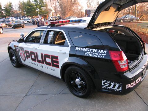 1991 Ford LTD Crown Victoria - Black and white police-liveried Dodge Magnum wagon marked POLICE Protect & Serve and Magnum Precinct, with open rear liftgate and roof ligh…