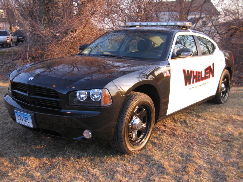 Front three-quarter of black Dodge Charger with WHELEN livery and light bar
