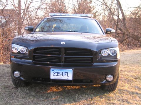 1991 Ford LTD Crown Victoria - Head-on front view of a black Dodge Charger with a roof light bar and a Connecticut license plate reading 235 UFL.