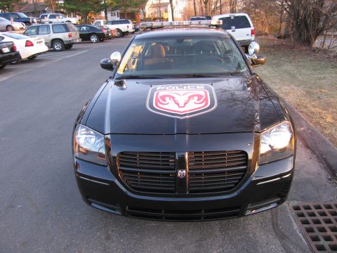 1991 Ford LTD Crown Victoria - Head-on view of a black Dodge Magnum police car showing a red ram-crest decal and POLICE text on the hood.