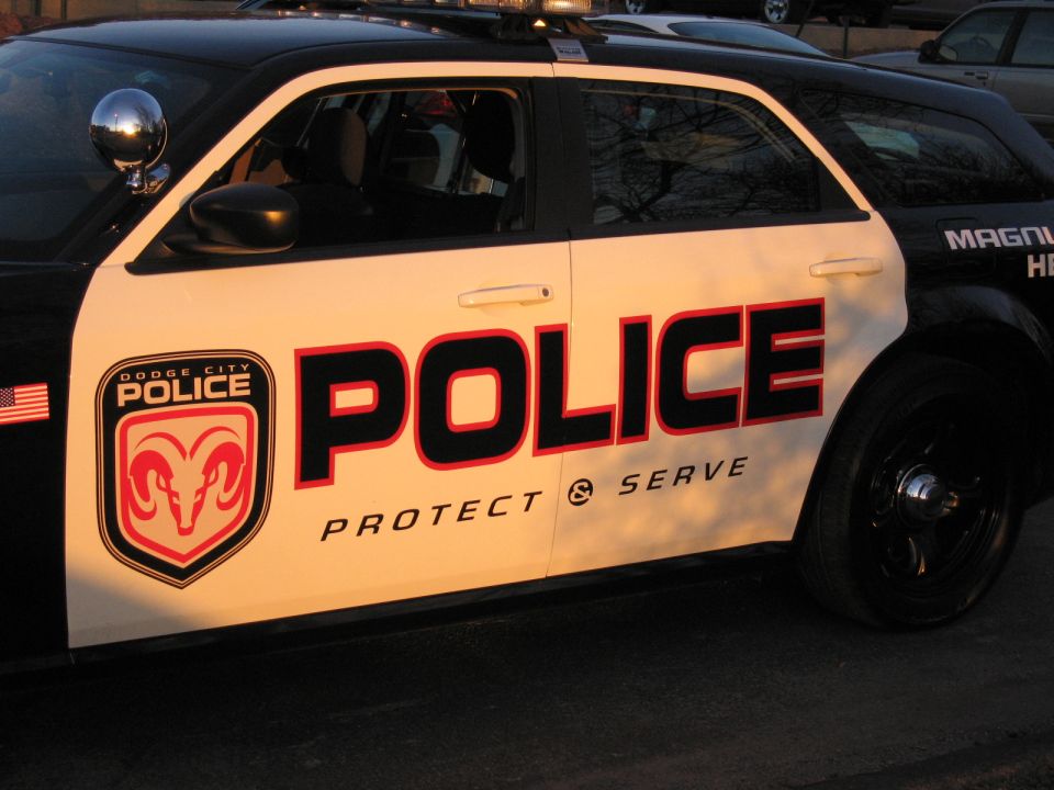 Close-up of POLICE Protect & Serve livery and ram shield on white car door