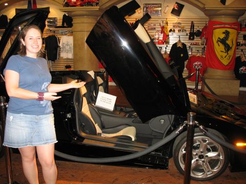 1997 Ford Probe - A black sports car with its doors open is displayed indoors, with a woman posing beside it.