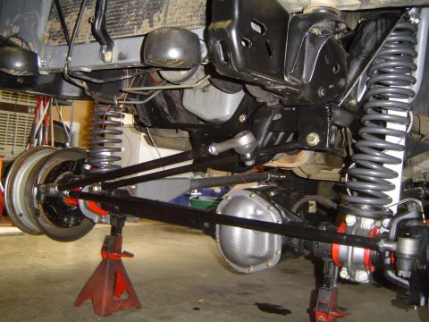 1989 Ford Bronco - Close-up view of the undercarriage, focusing on the suspension and axle components during installation.