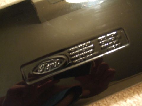 1995 Ford Probe - A close-up view of a Ford emblem and accompanying text on a vehicle part.