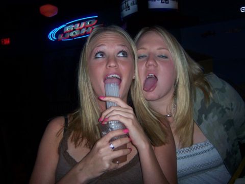 1989 Ford Bronco - Two women engage in a playful moment, with one holding a drink containing a tube.