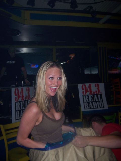 1989 Ford Bronco - A woman is captured mid-laugh at a lively event, with prominent '94.3 REAL RADIO' signage in the background.