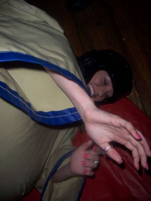 1989 Ford Bronco - A person in a sumo suit is lying down, wearing a black helmet and smiling.
