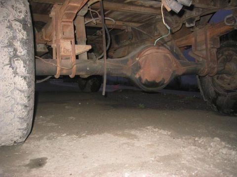 1986 Ford Bronco - Undercarriage view of a truck's rear axle and suspension components.