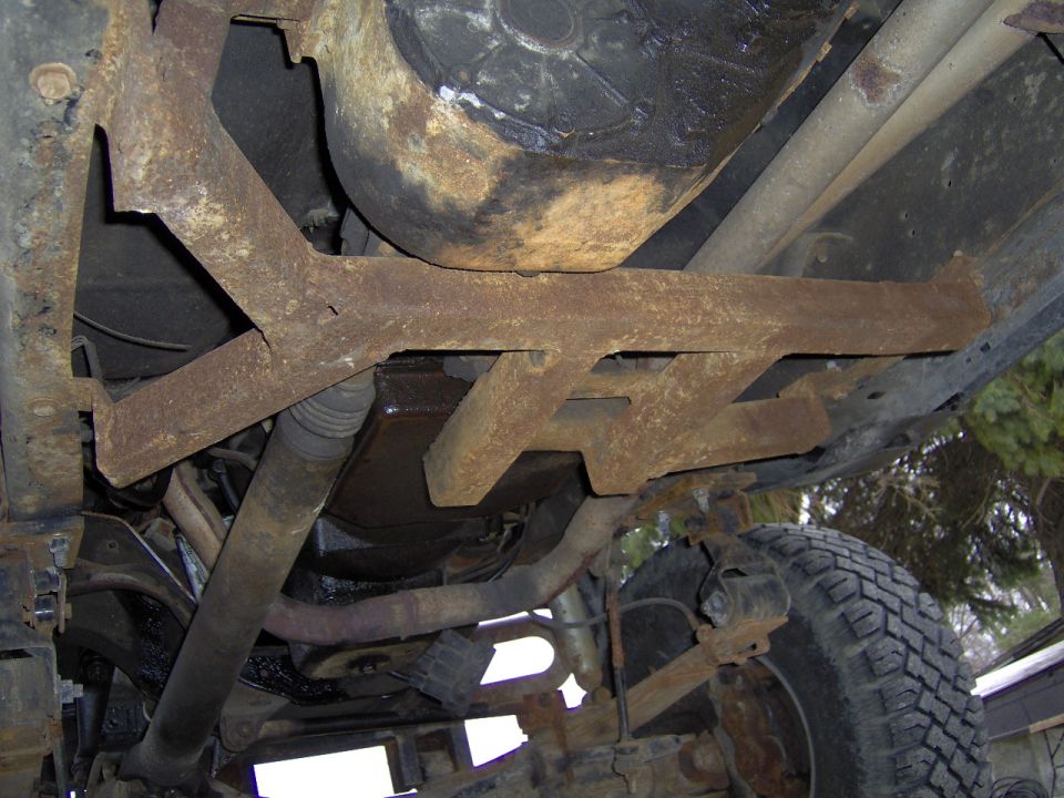 Undercarriage view of a 1986 Ford F-350 showing rusted frame components and suspension