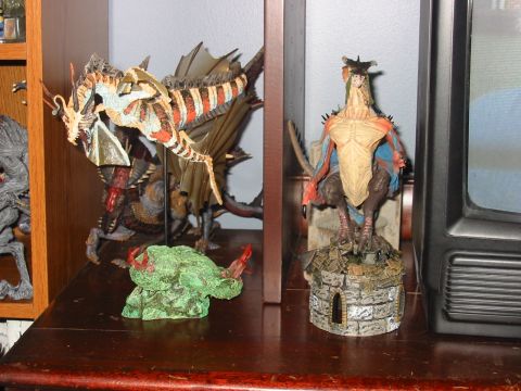 1991 Ford Bronco - Several fantasy creature figurines are displayed on a wooden shelf next to an old television set.