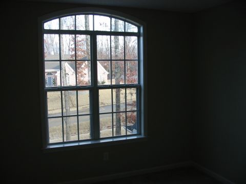 1991 Ford Bronco - A residential street scene is visible through a multi-paned arched window.