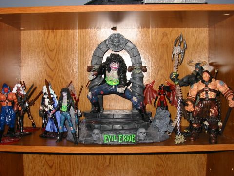 1991 Ford Bronco - A collection of action figures, including Evil Ernie, are displayed on a wooden shelf.