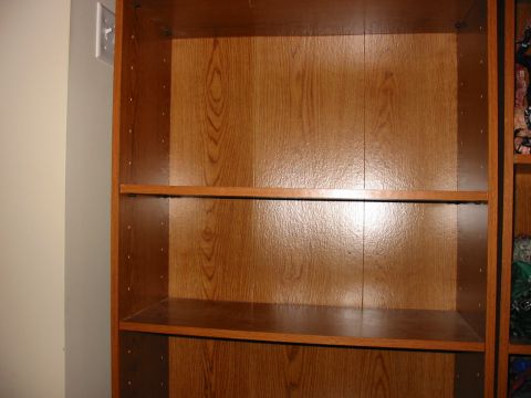 1991 Ford Bronco - An empty wooden bookshelf is shown, with a light switch visible on the wall to the left.