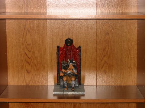 1991 Ford Bronco - A toy figure of a warrior sits on a throne, displayed on a wooden shelf.
