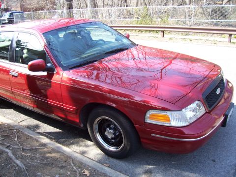 1999 Ford Crown Victoria - This red sedan, identified as a 1998 Ford Crown Victoria, is shown from a 3/4 front perspective.