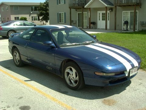 1995 Ford Probe - Blue 1995 Ford Probe with white racing stripes, parked in front of an apartment building.