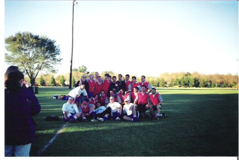 1992 Ford Bronco - A rugby team gathers on a grassy field for a group photograph under a clear sky.