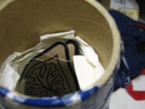 1991 Ford LTD Crown Victoria - Looking down into an open cardboard tube revealing tissue paper and a black tribal-style outlined decal inside.