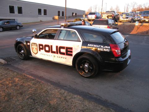 1991 Ford LTD Crown Victoria - Rear three-quarter view of a black-and-white Dodge Magnum police wagon marked POLICE and MAGNUM HEMI in a parking lot.