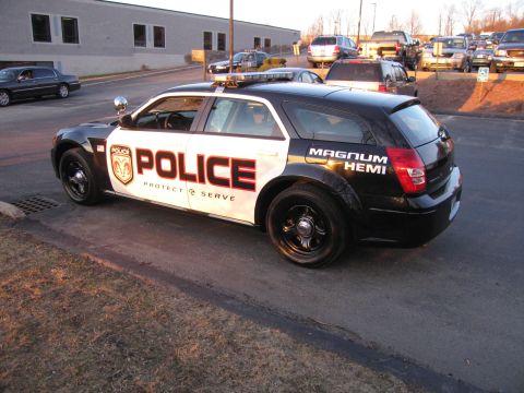 1991 Ford LTD Crown Victoria - Side-rear view of a black-and-white Dodge Magnum police wagon with POLICE and MAGNUM HEMI lettering and black steel wheels.