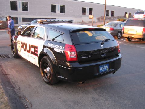 1991 Ford LTD Crown Victoria - Rear-quarter view of a black-and-white Dodge Magnum police wagon with MAGNUM HEMI badging and a Michigan plate reading ABS0444.