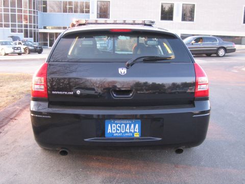 1991 Ford LTD Crown Victoria - Straight-on rear view of a black Dodge Magnum wagon with a roof light bar and a Michigan license plate reading ABS0444.