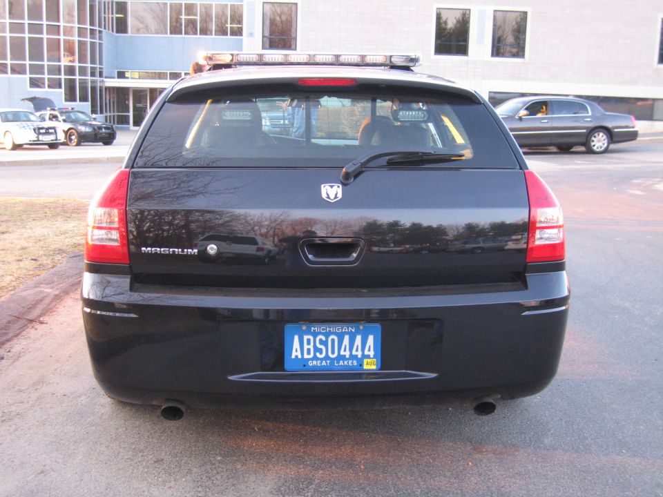 Rear of black Dodge Magnum wagon with light bar and Michigan plate ABS0444