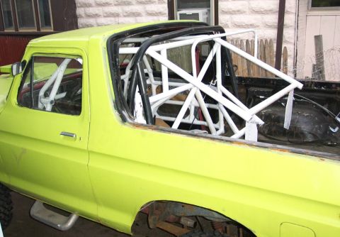 1978 Ford Bronco - Interior view of a yellow truck modified with a white rollcage.