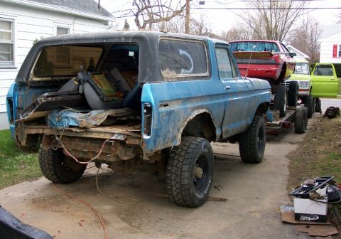 1978 Ford Bronco - A blue 1978 Ford Bronco is being towed on a trailer, with other vehicles visible.