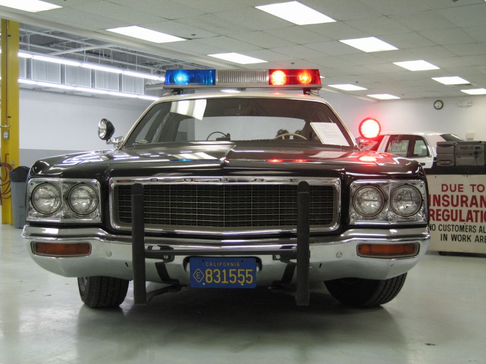 Front view of black-and-white Dodge police car with red and blue light bar