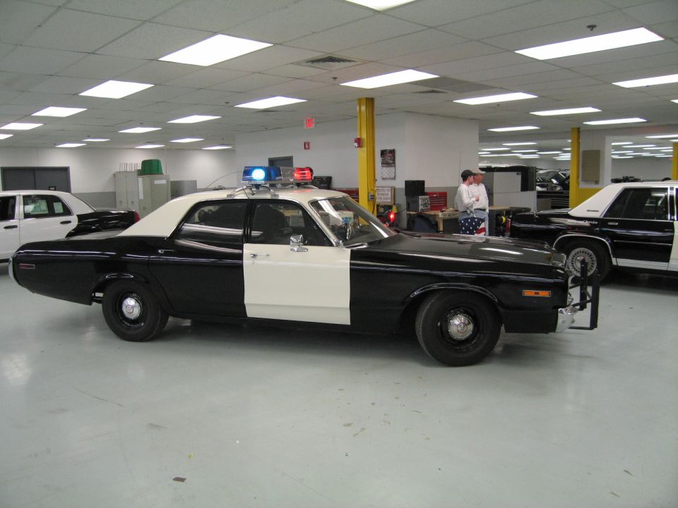 Side profile of black-and-white classic police sedan indoors