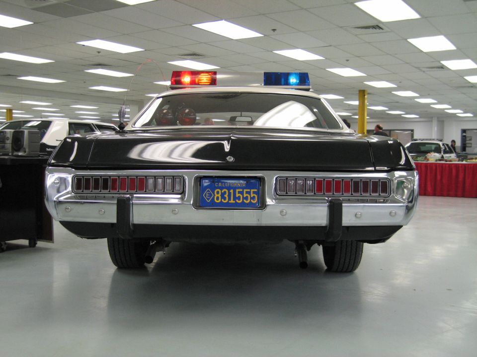 Rear view of black police car with full-width taillights and California plate