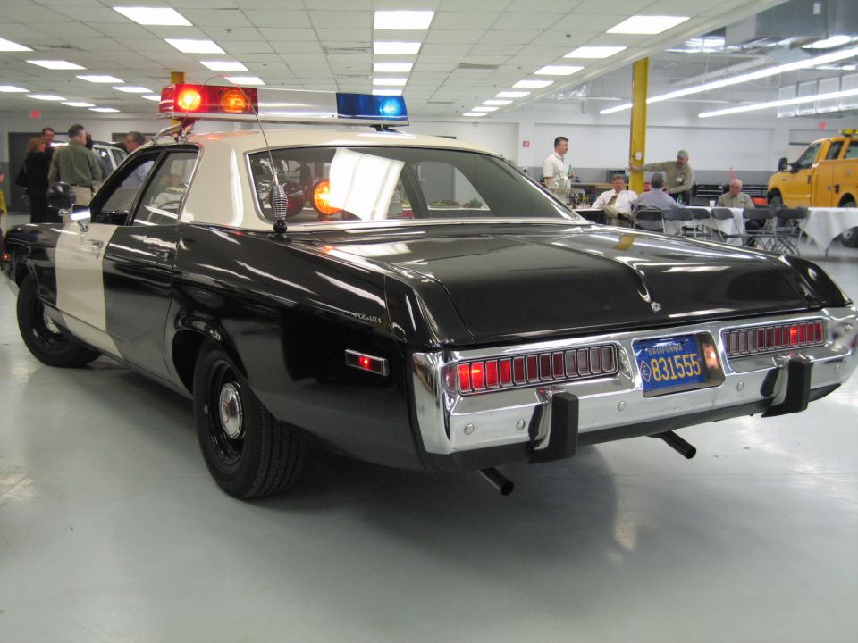 Rear three-quarter of black-and-white police car with lit amber roof light