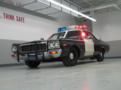 1991 Ford LTD Crown Victoria - low-angle front view of a black-and-white Dodge police car with lit beacons and California plate 831555.