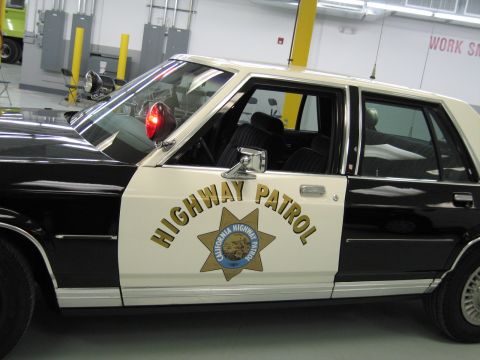 1991 Ford LTD Crown Victoria - Close-up of a California Highway Patrol sedan door showing HIGHWAY PATROL lettering and the gold seven-point star.