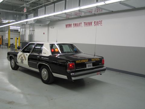 1991 Ford LTD Crown Victoria - Rear three-quarter view of a black-and-white CHP Ford sedan with Highway Patrol trunk lettering and plate 888849.