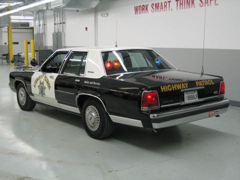 1991 Ford LTD Crown Victoria - Driver-side rear three-quarter view of a black-and-white CHP Ford sedan with Highway Patrol decals and plate 888849.