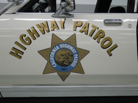1991 Ford LTD Crown Victoria - Close-up of a white police door panel with gold Highway Patrol lettering and the California Highway Patrol star emblem.