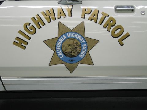 1991 Ford LTD Crown Victoria - Close-up of a white police door with gold Highway Patrol lettering and a detailed California Highway Patrol star emblem.