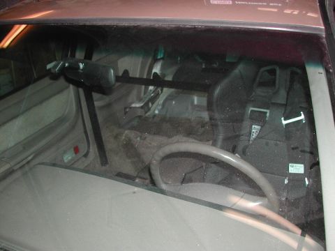 1993 Ford Thunderbird - The interior of a car is shown, a racing seat, harness, and roll cage.