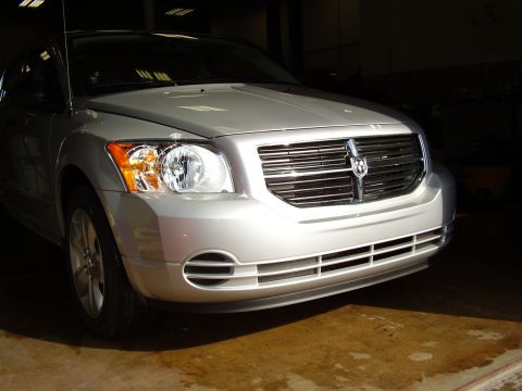 1997 Ford Taurus - This silver Dodge Caliber's front end is visible, showing its grille and headlights, along with a website watermark.