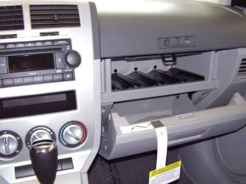 1997 Ford Taurus - The interior of a vehicle shows the dashboard, radio, climate controls, and an open glove box.