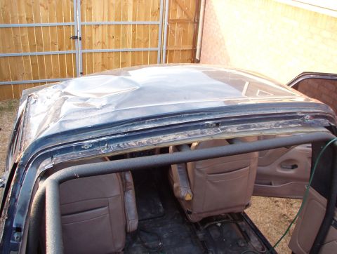 1994 Ford Bronco - The roof of this SUV has significant damage, with visible dents and creases.