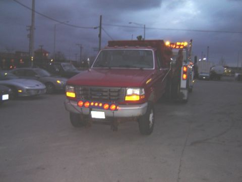 1992 Ford Bronco - A red 1992 Ford F-350 tow truck is parked outside at dusk, with other vehicles visible in the background.