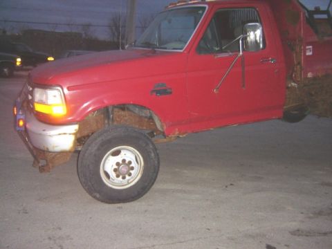 1992 Ford Bronco - This red pickup truck, likely a 1992 model, is shown from the front three-quarter view.