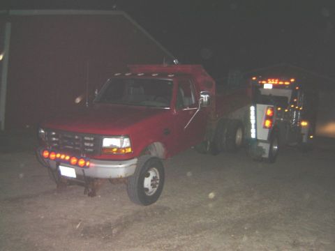 1992 Ford Bronco - A red 1992 Ford F-350 tow truck is parked at night, with another truck behind it.