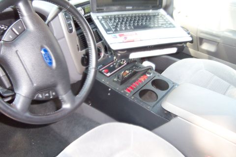 2005 Ford Explorer - The interior of a 2005 Ford Explorer is shown, a laptop and police radio equipment installed in the center console.