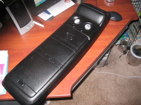 1991 Ford Bronco - This is a black plastic center console part, likely from a vehicle, two circular openings and multiple storage compartments.